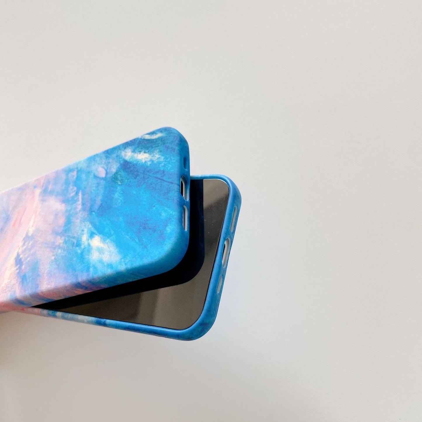 Artistic graffiti phone case with a vibrant blue and pink design on a plain background.
