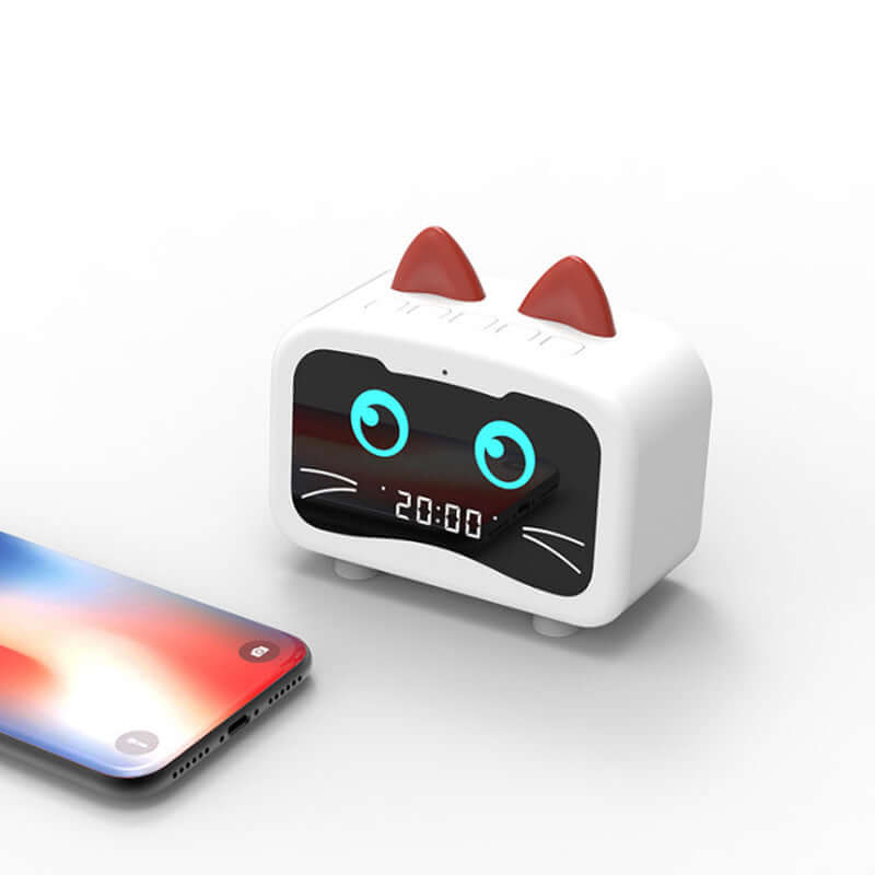 Cute cat-shaped wireless Bluetooth speaker next to a smartphone displaying the time.