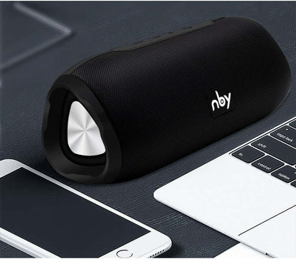 Bluetooth wireless speaker on a desk next to a smartphone and laptop, showcasing its sleek design and portable features.