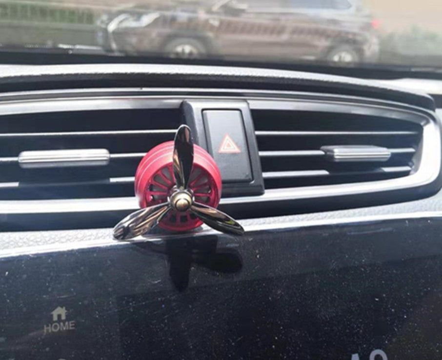 Car accessories car aromatherapy with a red fan-shaped air freshener on a car dashboard.