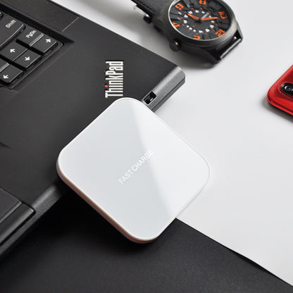 Earphone wireless charger resting on a laptop with a watch beside it, showcasing its sleek design.