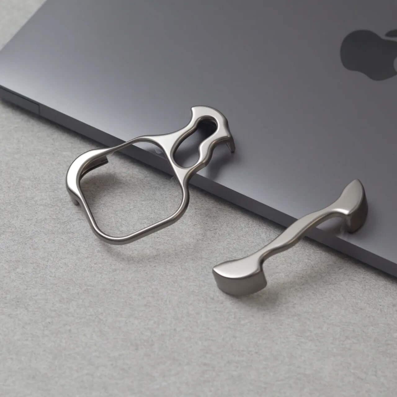 Zinc alloy iPhone 15 Pro Max case accessories on a sleek MacBook.