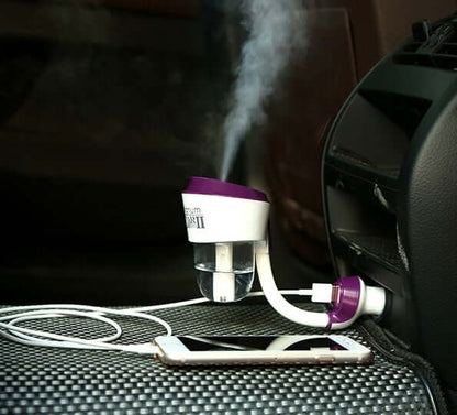 Car Aromatherapy Diffuser 50ml in vehicle, misting into the air, with a smartphone nearby