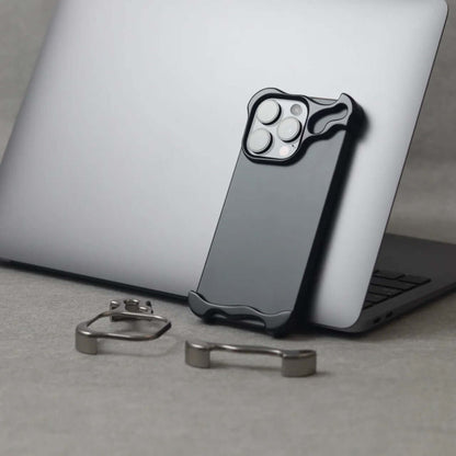 Zinc alloy iPhone 15 Pro Max case placed on a laptop, alongside metal accessories for enhanced protection.