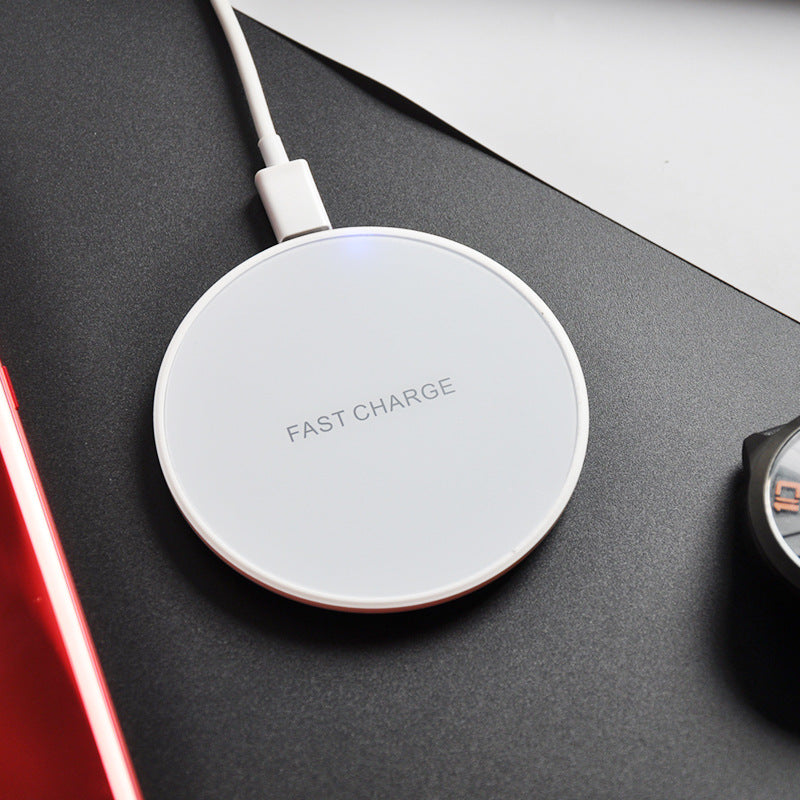 Earphone wireless charger with fast charge technology on a sleek black surface next to a smartphone and watch.