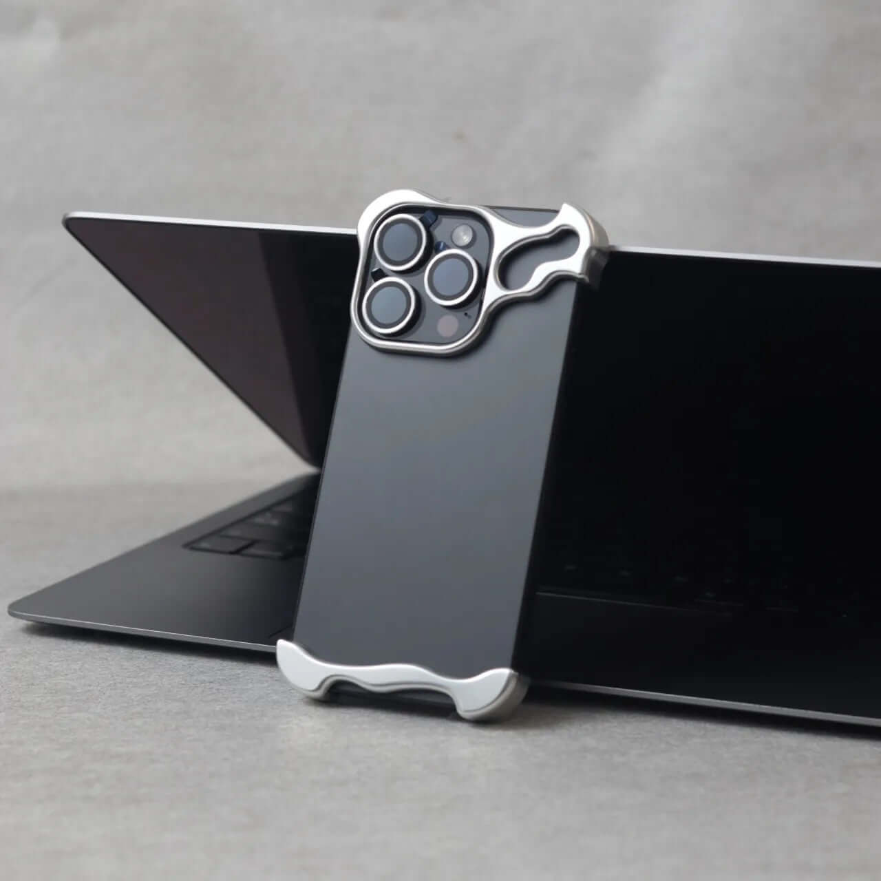 Zinc alloy iPhone 15 Pro Max case displayed on a laptop, highlighting its protective design and sleek aesthetics.