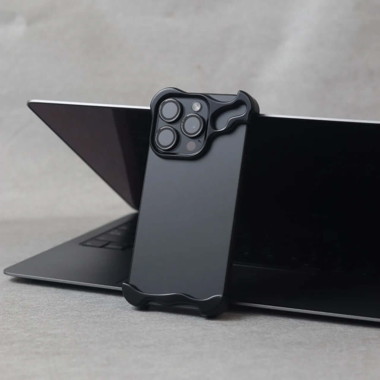 Zinc alloy iPhone 15 Pro Max case displayed on a laptop, showcasing its sleek, protective design.
